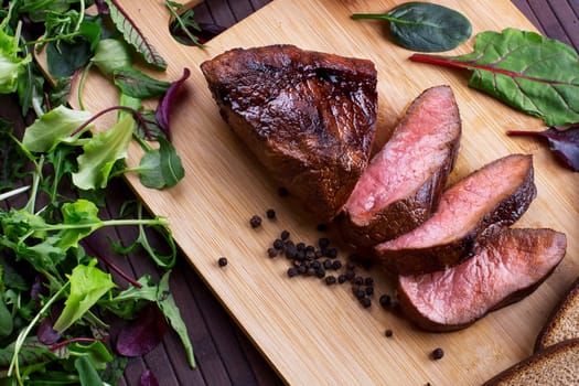 Close-up of Medium Rare Roast Beef with Fresh Herbs and  Vegetables