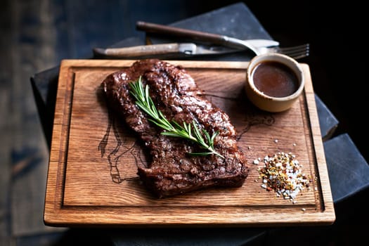 Beef steak. Piece of  Grilled BBQ beef marinated in spices and herbs on a rustic wooden board over rough wooden desk with a copy space. Top view..
