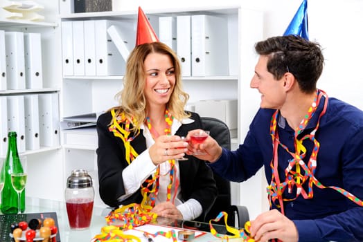 young businessman and businesswoman celebrating together in the office