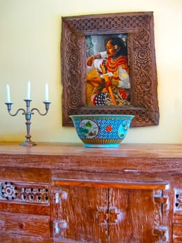 Bali, Indonesia - April 11, 2012: View of wooden furniture, painting, a work of art at Tanah Merah Art Resort at Bali