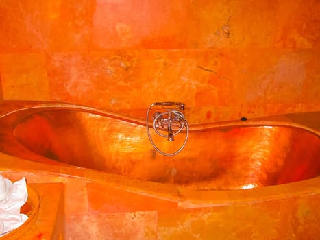 Bali, Indonesia - April 11, 2012: View of copper bathroom, a work of art at Tanah Merah Art Resort