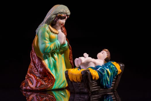 Christmas scene with Jesus and Mary on black background. Focus on Mary!