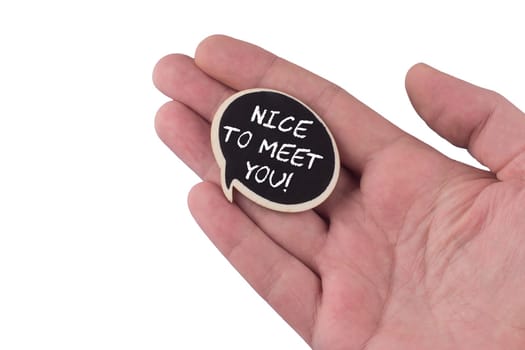 hand holding a wooden black speech bubble with nice to meet you text on it isolated on white