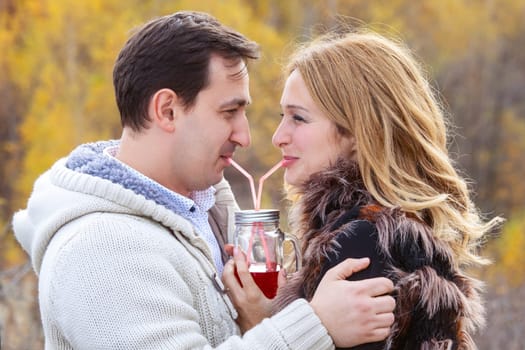 Happy young couple drinking red tea from the same pot