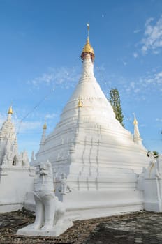 Lion statue and white pagoda at Wat Phra That Doi Kong Mu, Mae Hong Son, Thailand.