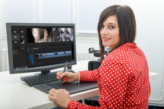 young brunette female designer using graphics tablet for video editing