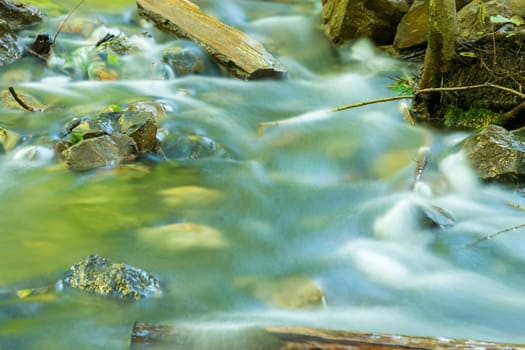 The movement of water in a forest stream shot with long exposure