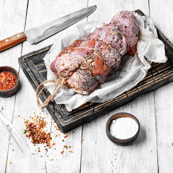 raw meat in spicy spices and seasonings on the kitchen board