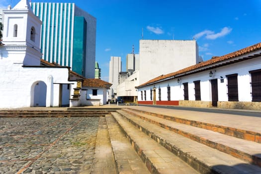 View of the historic La Merced church in Cali, Colombia with modern buildings in the background
