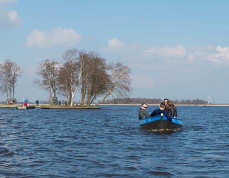 GIETHOORN, NETHERLANDS - APRIL 3, 2016: Unknown family enjoying their boating trip around Giethoorn, also called the Venice of the north
