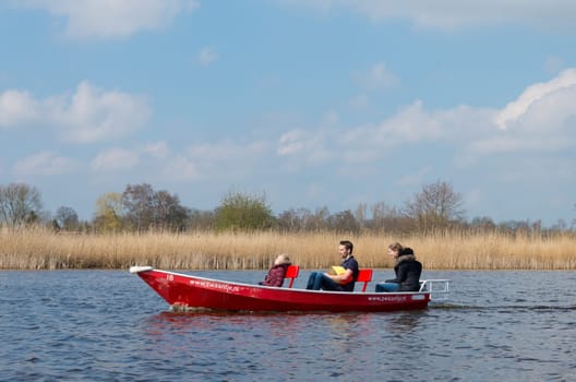 GIETHOORN, NETHERLANDS - APRIL 3, 2016: Unknown family enjoying their boating trip around Giethoorn, also called the Venice of the north