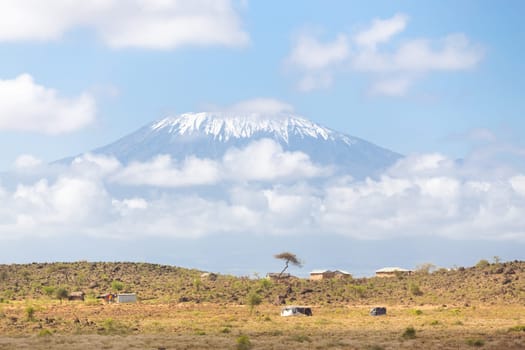 Mount Kilimanjaro, Tanzania., the highest mountain in Africa. Traditional african savannah village in foreground.