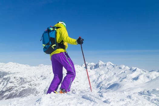 Freeride skier on the top of the mountain. Extreme winter freeride. Amazing landscape of snowy Alp mountains in the background. Vogel, Slovenia.