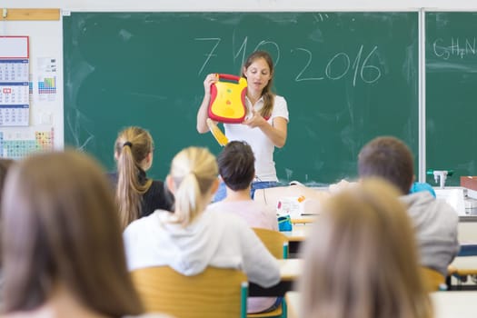Instructor teaching first aid cardiopulmonary resuscitation course and use of automated external defibrillator workshop in primary school class.