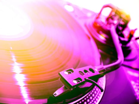 dj turntable with violet and orange light