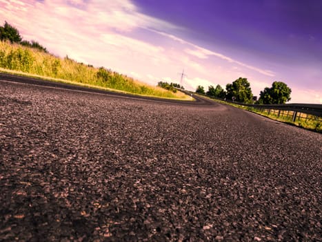 a road in evening time with violet cloudy sky