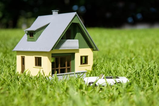 house and car on a green meadow in summer