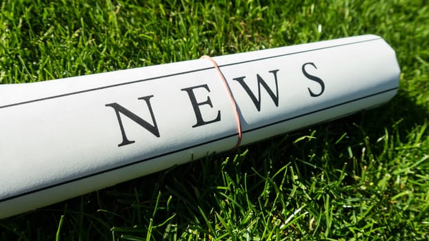 newspaper on green meadow in summer