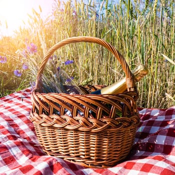 picnic blanket with champagne, strawberries and croissant