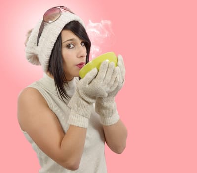 pretty young brunette woman with a cup of tea on pink background