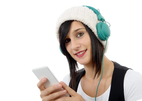 young brunette listening to music with headphones and  phone on white