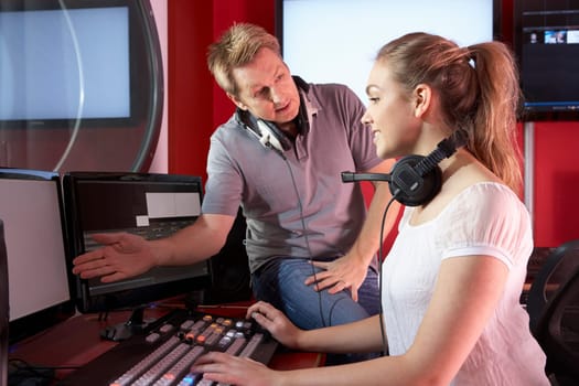 Media Student With Tutor Working In Film Editing Class