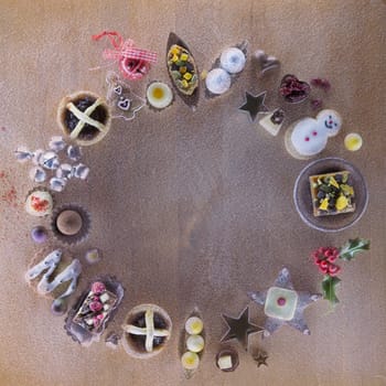 Christmas treats and accessories presented in a circle on a wooden chopping board.