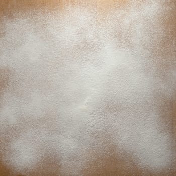Icing sugar on a wooden board background.