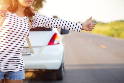 woman hitchhiking looking for help with her broken car on the road