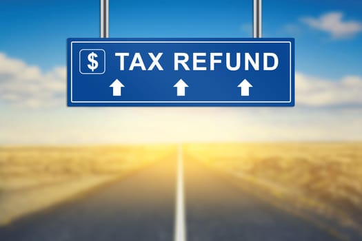tax refund words on blue road sign with blurred background