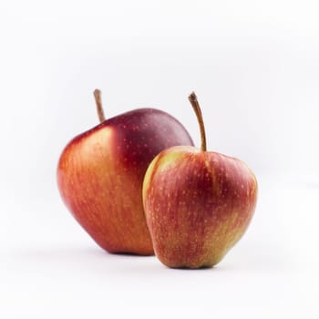 front view of two red apples next to each other isolated on white background