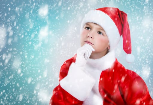 little boy thinking wearing Christmas outfit on snowy background