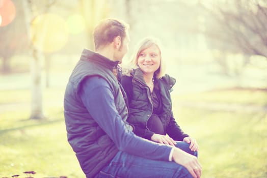young man and his pregnant wife in the park