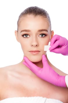 Beautiful face cleansing Cosmetic skincare spa beauty treatment with pink gloves and sponge, on white.
