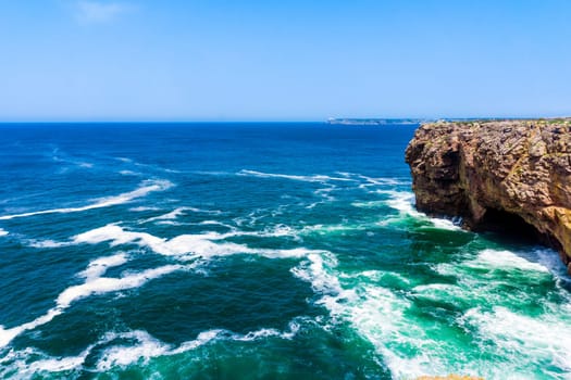 Ocean wave background. Cliff coastline in Sagres, Algarve, Portugal