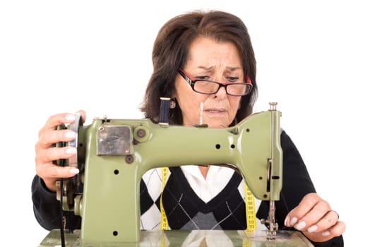 Beautiful senior woman with sewing machine isolated in white