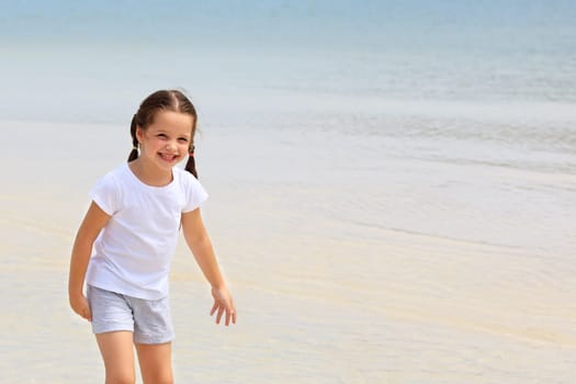 Adorable little girl have fun on the beach