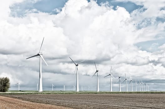 row wind turbines in an agricultural dutch landscape harsh filtered
