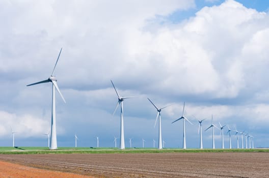 row wind turbines in an agricultural dutch landscape