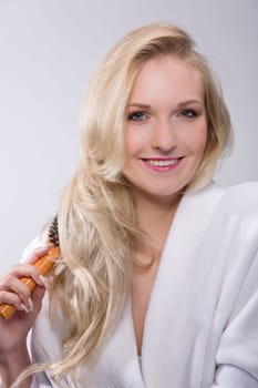 Girl brushes her blonde hair