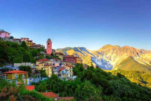 View of a mountain village at sunset with the quarries in the background