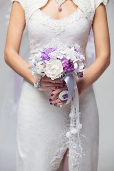 Closeup of winter bride holding beautiful bouquet from artificial art clay flowers