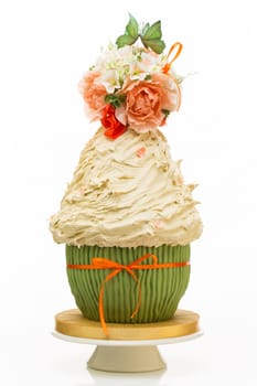 Luxurous wedding tort looking like big cupcake with flower bouquet and two kissing butterflies on the top