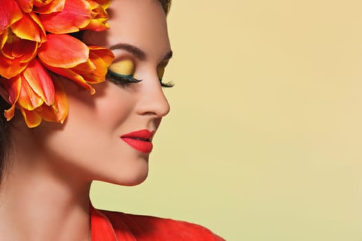 Attractive young woman with bright make-up and flowers on her head