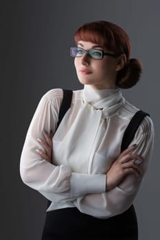 Closeup of beautiful young woman in white blouse and glasses over grey background
