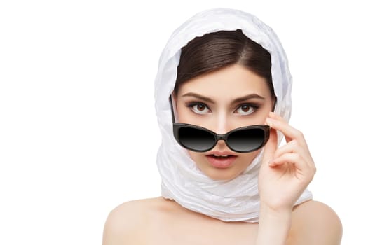 Closeup portrait of beautiful young woman in white scarf on head holding black sunglasses. Isolated over white background. Copy space.