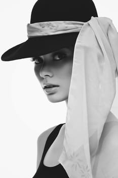 Beautiful woman looking like Audrey wearing black hat and light scarf