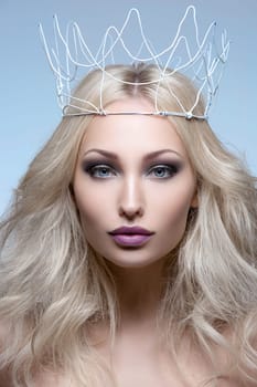 Beautiful young woman with crown. Cold tones. Copy space.