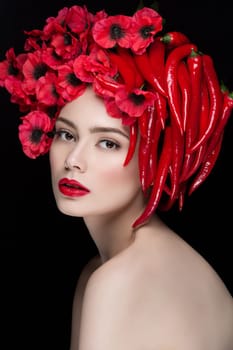 Closeup portrait of beautiful young woman with chilli peppers and flowers on head. Red lips.