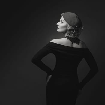 Beautiful lady in beret. Film noir retro style. Over black background. Monochrome.